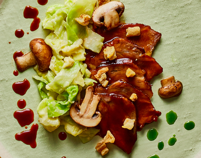 Een heerlijk hartig, winters gerecht van gestoofde kalfswang, spitskoolstamppot en paddenstoelen. Maar dan in een culinair jasje met kruidenÂ­jus en boerenkoololie.