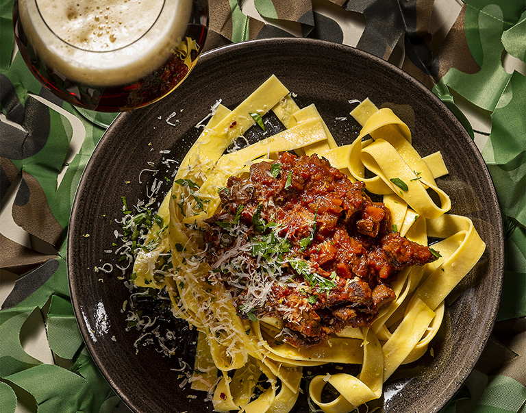 Sukade gestoofd in bier en wildbouillon, geserveerd met pappardelle. Bestrooid met pecorino, peterselie en citroenrasp voor een verrassende twist.