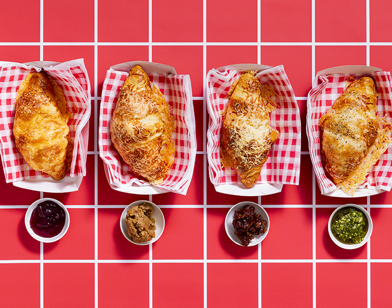 Hollandse geitenkaascroissants: krokante afbakcroissants met gesmolten geitenkaas, geserveerd met zoete dadelpuree en granaatappelmelasse.