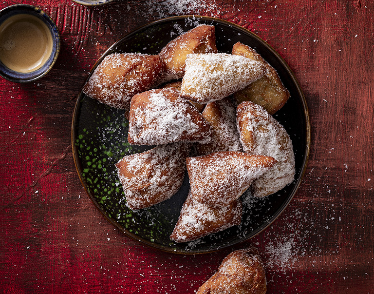 Luchtige, gefrituurde donuts met kokos en banaan, gekruid met garam masala. Perfect voor een zoete traktatie bij de koffie!